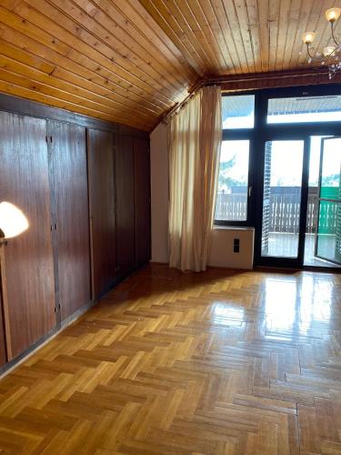 an empty room with a wooden floor and large windows at Luxury 3 BR Vila in a forest 10min drive from city center in Budapest