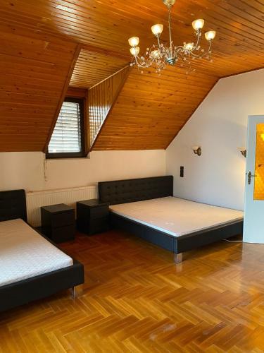 a room with two beds and a wooden ceiling at Luxury 3 BR Vila in a forest 10min drive from city center in Budapest