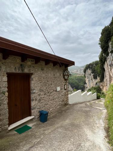 un edificio de piedra con una puerta a un lado en Agriturismo Orrido di Pino, en Agerola