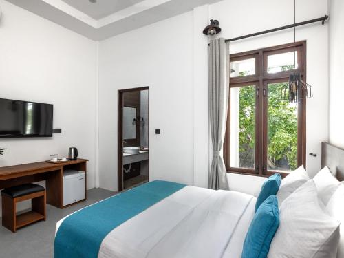 - une chambre blanche avec un lit et une fenêtre dans l'établissement Fushi Beach Guesthouse, à Fenfushi