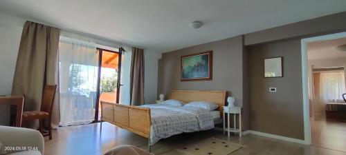 ein Schlafzimmer mit einem Bett und einem großen Fenster in der Unterkunft Apartment Pergola in Veprinac