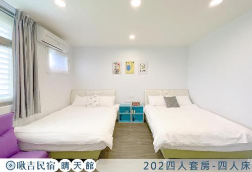 two beds in a room with white walls at 啾吉民宿晴天館 羅東五結8到20人包棟民宿 in Wujie