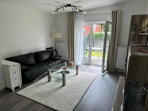 ein Wohnzimmer mit einem schwarzen Sofa und einem Tisch in der Unterkunft Villarina in Dresden