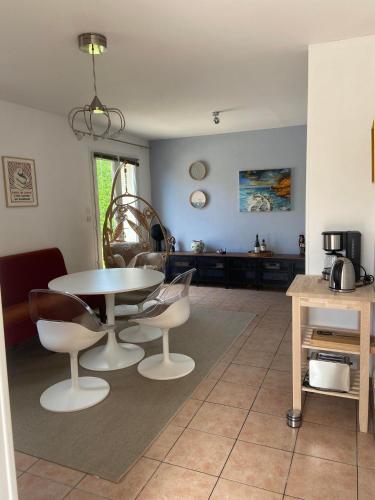 un salon avec une table et des chaises dans l'établissement L'Océan, maison avec jardin clos, à Tracy-sur-Mer