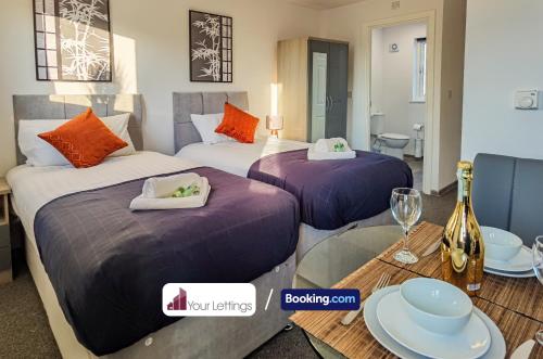 a hotel room with two beds and a table with glasses at 4 Bedroom Contractor House By Your Lettings Short Lets & Serviced Accommodation Peterborough With Free WiFi in Peterborough