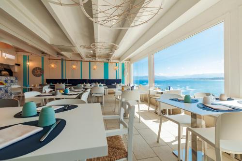 a restaurant with tables and chairs with a view of the ocean at Marina di Petrolo Hotel & SPA in Castellammare del Golfo