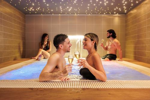 a group of people in a hot tub with wine glasses at Marina di Petrolo Hotel & SPA in Castellammare del Golfo
