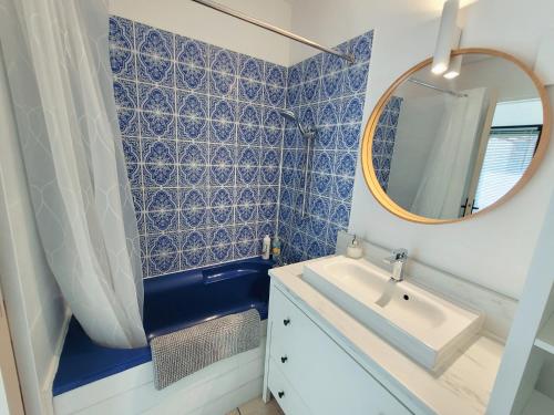 une salle de bain avec un lavabo et un miroir dans l'établissement Maison de ville au calme avec jardin et parking, à La Rochelle