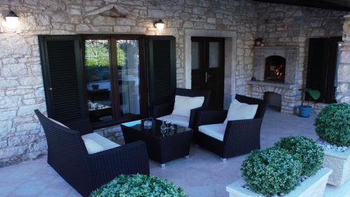 a patio with wicker chairs and a fireplace at Villa Dina in Tar