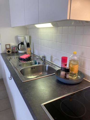 a kitchen counter top with a sink and a sink at DUNAS, appartement, garage, 200m van strand en centrum in Koksijde