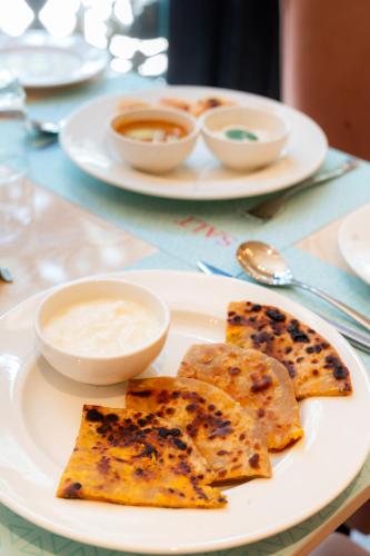 a white plate with some food on a table at Playsales Scarlet Vijay Nagar Indore in Indore