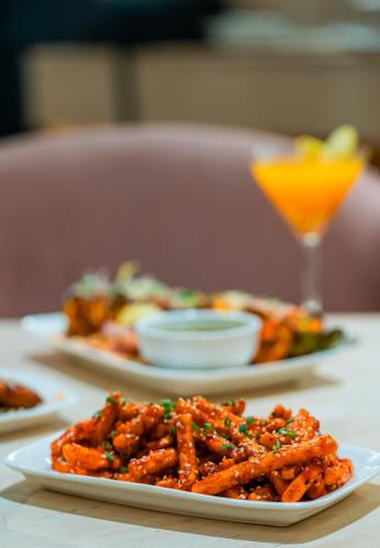 a plate of food on a table with a drink at Playsales Scarlet Vijay Nagar Indore in Indore