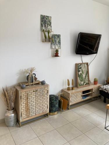 a living room with a tv on a white wall at DUNAS, appartement, garage, 200m van strand en centrum in Koksijde