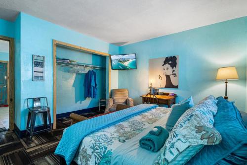 a blue bedroom with a large bed with blue sheets at Blue Bell Apartment Hotel in Fort Lauderdale
