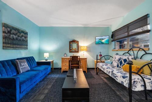 a blue living room with a couch and a bed at Blue Bell Apartment Hotel in Fort Lauderdale