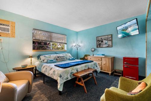 a bedroom with a bed and two chairs and a couch at Blue Bell Apartment Hotel in Fort Lauderdale