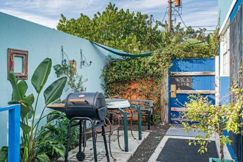 a patio with a grill and a blue wall at Blue Bell Apartment Hotel in Fort Lauderdale