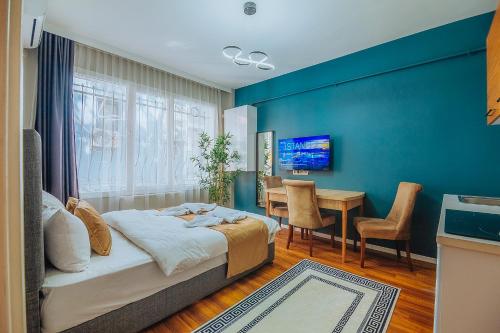a bedroom with a blue wall with a bed and a table at Taksim Wonder Suites in Istanbul