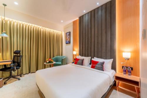 a hotel room with a large bed and a desk at Playsales Scarlet Vijay Nagar Indore in Indore