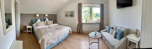 ein Schlafzimmer mit einem Bett und einem Sofa in der Unterkunft Hotel Restaurant Ostsee-Anker in Langballig