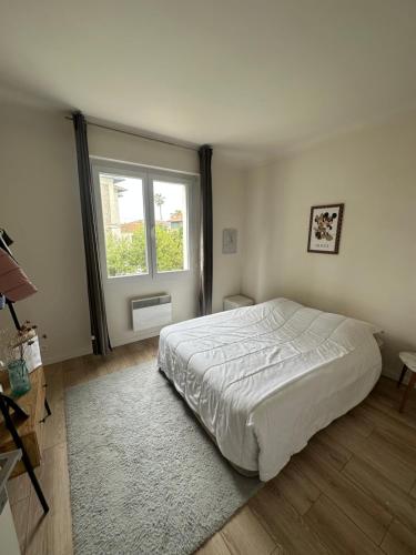 une chambre avec un grand lit et une fenêtre dans l'établissement Magnifique appartement Cannes Californie Parking, à Cannes