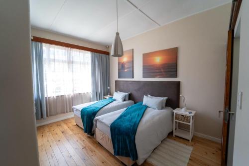 een slaapkamer met twee bedden en een raam bij Haus Boost Self Catering in Swakopmund