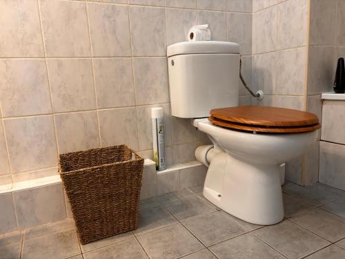 a bathroom with a toilet with a wooden seat and a basket at Mondello Hotellerie&Consultant : Appartement de standing 47m2 avec piscine Cannes in Cannes