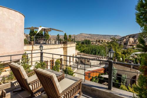 a balcony with chairs and a view of the mountains at Utopia Cave Cappadocia in Urgup