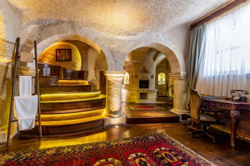 a living room with a staircase and a room with a table at Utopia Cave Cappadocia in Urgup