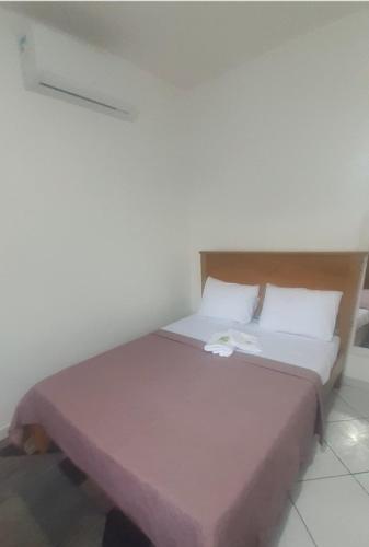 ノヴァ・イグアスにあるSuite 2, Casa Amarela, Segundo Andarのベッドルーム1室(ピンクの毛布付きの大型ベッド1台付)