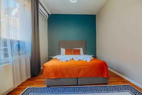 a bedroom with an orange bed with a blue wall at Taksim Wonder Suites in Istanbul