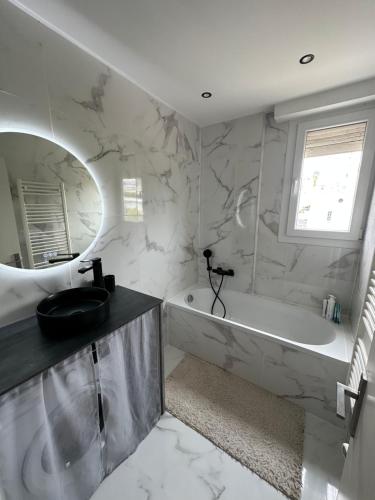 une salle de bain blanche avec une baignoire et un lavabo dans l'établissement Magnifique appartement Cannes Californie Parking, à Cannes