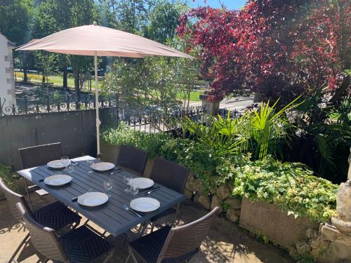 une table bleue avec des chaises et un parasol dans l'établissement Villa RENNAISSANCE - Proche Mer - Parking - Ménage & Linge inclus, à La Rochelle