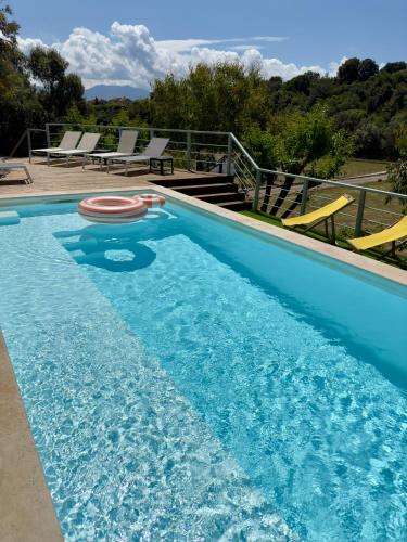 une piscine avec une bouée de sauvetage rouge dans l'eau dans l'établissement VillaSerenita Piscine chauffée et SPA à Ajaccio, à Ajaccio