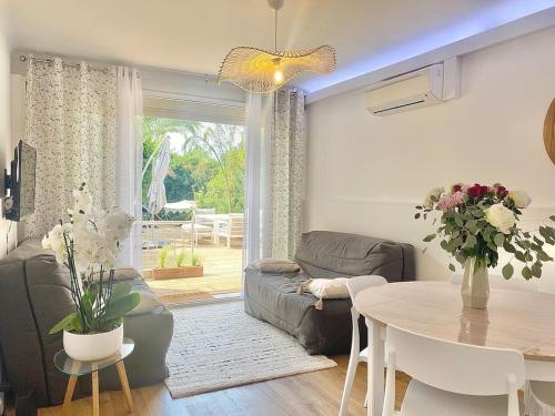 un salon avec une table et un canapé et une salle à manger dans l'établissement Cannes appartement 1 chambre - Victoriam, à Cannes