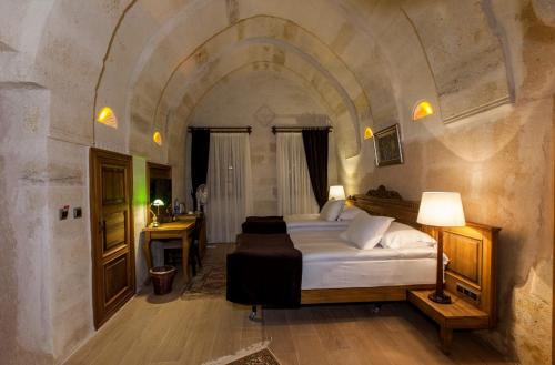 a bedroom with a large bed in a stone room at Utopia Cave Cappadocia in Urgup