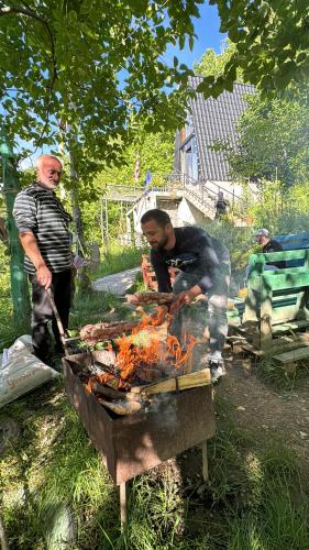 Dwóch mężczyzn gotuje jedzenie na grillu. w obiekcie N STORY w mieście K'eda