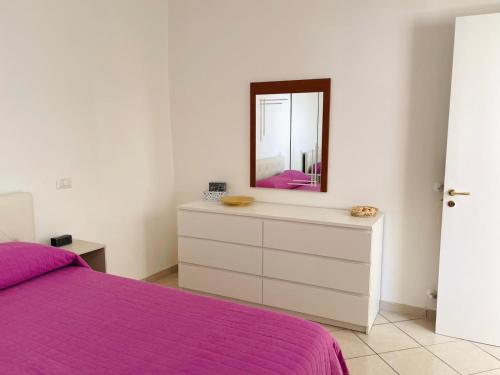 a bedroom with a purple bed and a mirror at Il cortile fiorito in Scala