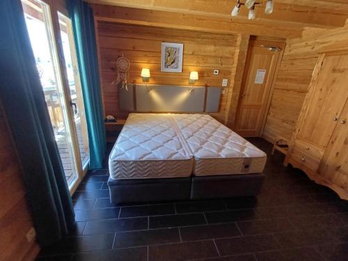 a bedroom with a bed in a wooden room at Chalet La Breche in LʼHuez