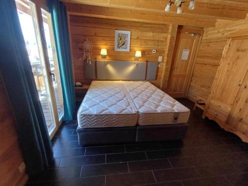 une chambre avec un lit dans une pièce en bois dans l'établissement Chalet La Breche, à Huez