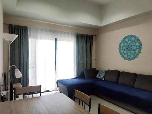 a living room with a blue couch and a window at Villa LunaSole Samui in Koh Samui 