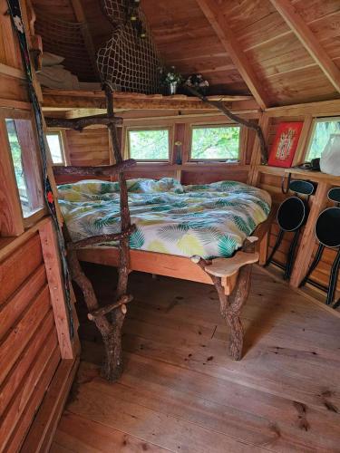 - un lit au milieu d'une pièce dans une cabine dans l'établissement Cabane Dans Les Arbres - Les Lutins, à Mechmont