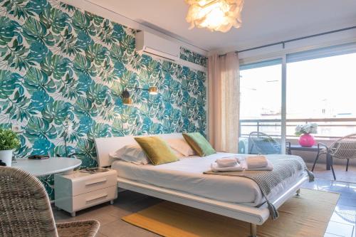 een slaapkamer met een bed met een blauwe en groene muur bij Sweet Inn - Maison Blanche in Juan-les-Pins