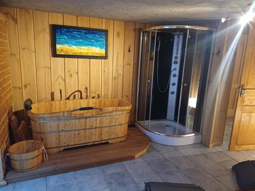 a bathroom with a wooden tub and a shower at Chalet La Breche in LʼHuez