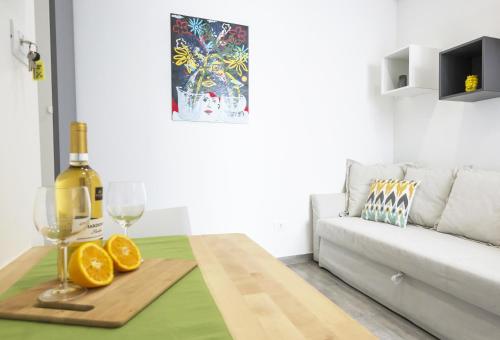 シラクーサにあるArtemide House - Monolocale Ortigia Wifiのワインのボトルとオレンジ2個が置かれたテーブル