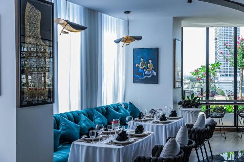 a dining room with two tables and a blue couch at Chaiya Palace Hotel in Phnom Penh