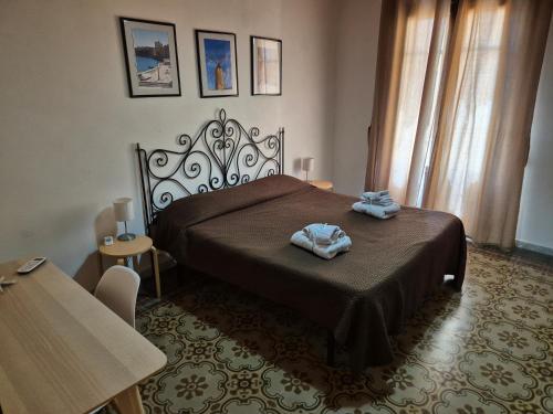 una camera da letto con un letto e due asciugamani di Apartment Trapani's heart a Trapani