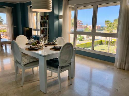 a dining room with a white table and chairs at BRISA DEL MAR - 200m to the beach in Oliva