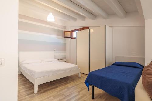 a bedroom with two beds and a blue blanket at Marina di Petrolo Apartments in Castellammare del Golfo