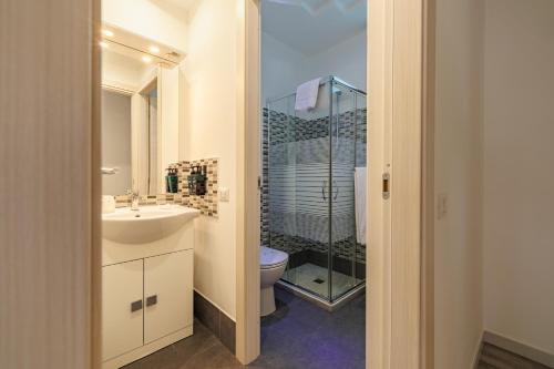 a bathroom with a sink and a toilet and a shower at Marina di Petrolo Apartments in Castellammare del Golfo